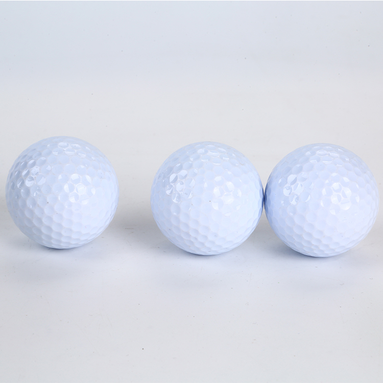 Unbranded white golf balls arranged for golf ball brand comparison